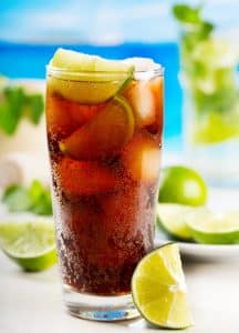 Cocktail Cuba Libre în pahar highball, cu gheață și felie de lime