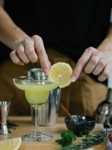Cocktail Margarita cu marginea paharului tapetată cu sare și felie de lime