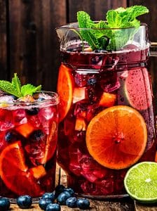 Carafă de Sangria cu vin roșu, felii de portocală, măr și lămâie