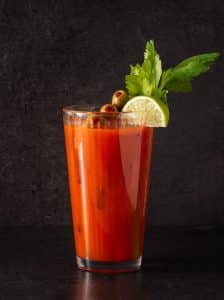 Cocktail Bloody Mary garnisit cu tijă de țelină și felie de lămâie