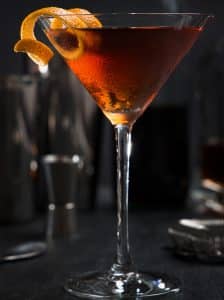 Manhattan cu coniac și vermut dulce, garnisit cu coajă de portocală